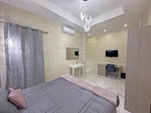 Dormitorio con cama, escritorio y TV en Ta' Stef's Holiday Suites en San Lawrenz