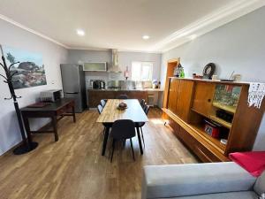 a living room with a table and a kitchen at A Tintureira in São Martinho de Antas