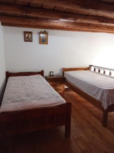 2 camas en una habitación con suelo de madera en house FYNTIKAKH - SKALA, en Sinoikismós Kámbos
