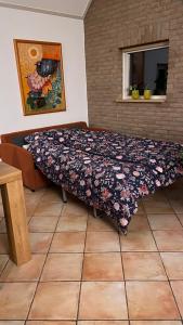 a bed in a room with a blanket on it at Vakantiehuis De Fiere - wijngaard Zutphen in Zutphen