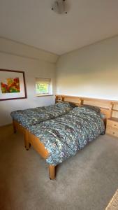 ein Schlafzimmer mit einem Bett mit einer Bettdecke darauf in der Unterkunft Vakantiehuis De Fiere - op erf wijngaard De Fiere Wijnakker in Zutphen