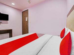 1 dormitorio con 1 cama roja y blanca y TV en OYO Flagship 81337 New Gour Plaza en Nueva Delhi