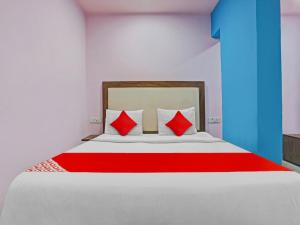 1 dormitorio con 1 cama grande con almohadas rojas en OYO Flagship 81337 New Gour Plaza en Nueva Delhi