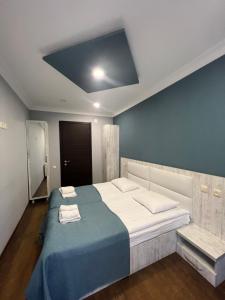 a bedroom with a large bed with a blue wall at Hotel Shgedi Mestia in Mestia