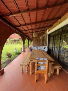 a wooden table and chairs on a covered patio at Casa dos Arcos in Gueima