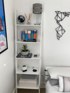 um quarto com uma prateleira de livros brancos ao lado de uma cama em Tasteful 2BD Flat wOpen Plan Living - Blackheath! em Londres