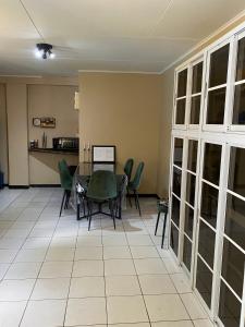 a dining room with a table and green chairs at Osso fu mi ati (huis van mijn hart) in Paramaribo