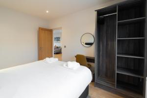 1 dormitorio con cama blanca y espejo en Dingle Way Snug, Luxury apartment, en Dingle