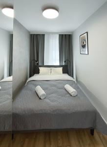 a bedroom with a large bed with two pillows on it at Like Home Apartments in Kraków