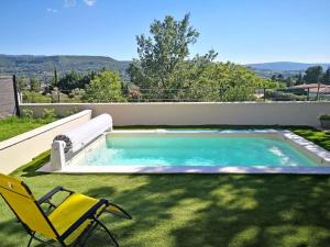 a swimming pool with a yellow chair and a yellow chair at Villa Abelha en Provence in Apt