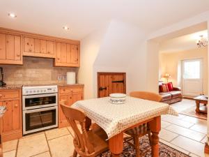 a kitchen with a table and chairs in a room at Kath's Cottage in Heacham