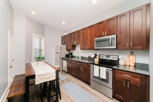 a kitchen with wooden cabinets and a stove top oven at Walkable and Spacious Apt - Parking -- GroupStay in Pittsburgh