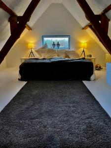 um quarto com uma cama grande num sótão em The cave em Sint-Denijs-Westrem
