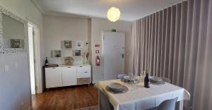 uma sala de jantar com uma mesa com uma toalha de mesa branca em Highrise Madalenas Apartment no Funchal