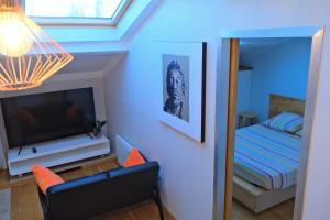 a living room with a television and a bedroom at Isabelli in Aix-en-Provence