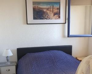 ein Schlafzimmer mit einem Bett mit einem Bild an der Wand in der Unterkunft Pretty 30 m close to the sea in Leucate