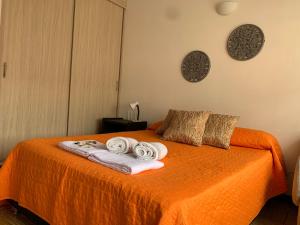 a bedroom with an orange bed with towels on it at Apartamento Malí en Cali in Cali