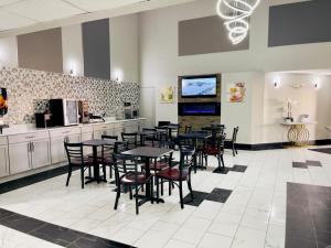 a dining room with tables and chairs and a kitchen at Super 8 by Wyndham Shakopee in Shakopee