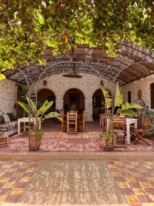 a patio with tables and chairs in a building at Riad Sanam - Adults only in Essaouira