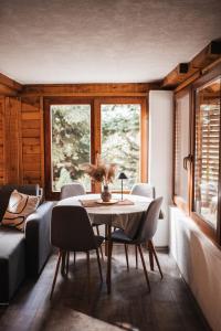 a dining room with a table and chairs and windows at Vikendica MINI in Jotanovići