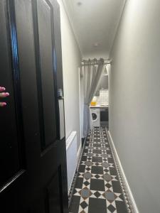 a hallway with a black door and a checkered floor at Matipa-Given Apartments Eastleigh Southampton in Eastleigh