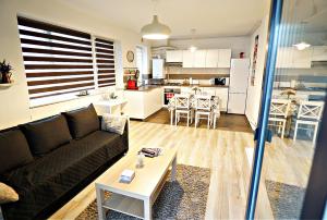 ein Wohnzimmer und eine Küche mit einem Sofa und einem Tisch in der Unterkunft Relaxing Coresi Place in Braşov