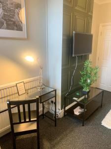 a room with a desk and a tv and a chair at Matipa-Given Apartments Eastleigh Southampton in Eastleigh
