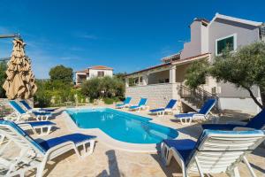 une piscine avec des chaises longues et une villa dans l'établissement Villa Decima, à Milna