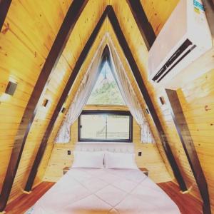 a large bed in a room with a window at Refuge Green mountain in Urubici