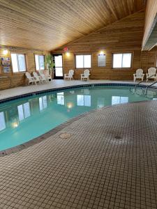 a large swimming pool in a building with chairs at Super 8 by Wyndham Shakopee in Shakopee