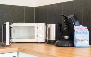 encimera de cocina con microondas y cafetera en Modern cozy apartment - three box spring beds, en Gronau