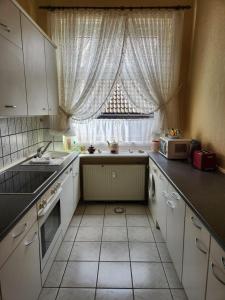 a kitchen with white cabinets and a window with a microwave at Apartment 16, Im Zentrum von Braunlage in Braunlage