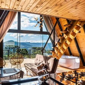 a living room with a couch and a large window at Refuge Green mountain in Urubici