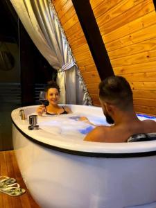 a man and a woman sitting in a bath tub at Refuge Green mountain in Urubici