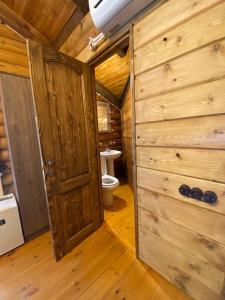 een badkamer met een toilet in een houten cabine bij Arte Jermuk Lux Cottage in Dzjermoek