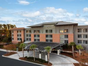 an office building with a courtyard with palm trees at Courtyard by Marriott Charleston Summerville in Summerville