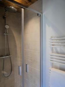 a shower with a glass door in a bathroom at La ferme d'Hauteluce - Chambre d'hôtes in Hauteluce