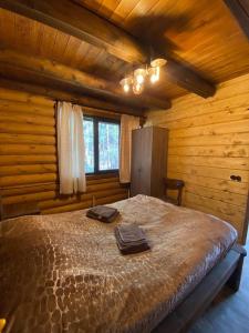 - une chambre avec un grand lit dans une cabane en rondins dans l'établissement Arte Jermuk Lux Cottage, à Jermuk