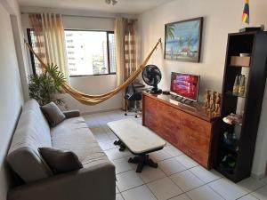 a living room with a couch and a tv at Jaqueira Home Service in Recife