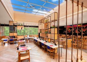 a dining room with tables and chairs and windows at Ginger Mumbai Airport in Mumbai