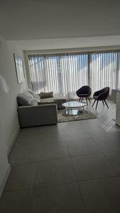 een woonkamer met een bank en een tafel en stoelen bij Ático lujo OASIS in Estepona