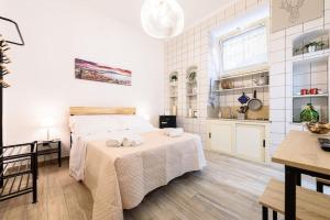 a white bedroom with a bed and a kitchen at Vomero Dream Naples in Naples