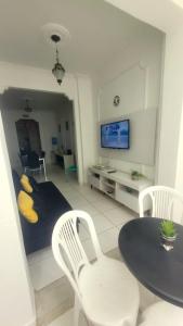 uma sala de estar com uma mesa e cadeiras e uma televisão em 3 quartos Copacabana no Rio de Janeiro