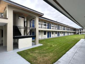 an empty courtyard of an apartment building with a lawn at Days Inn by Wyndham St Augustine I-95-Outlet Mall in Saint Augustine