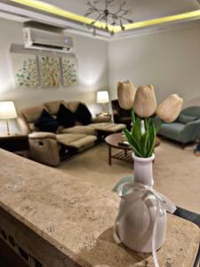 un jarrón con flores en un mostrador en una sala de estar en The Arabella House - Madinaty, en Madinaty