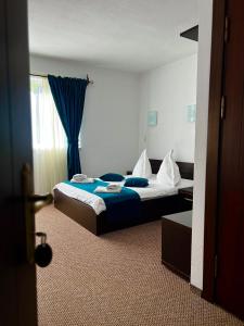 una camera d'albergo con due letti e una finestra di Pensiunea Orzan a Moieciu de Sus