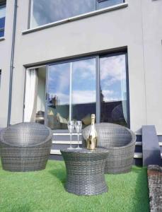 a patio with two chairs and a table with wine glasses at Contemporary Seaside Apartment in Bangor +7 photos