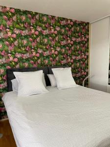 - une chambre avec un lit orné d'un mur fleuri dans l'établissement Place privée/Le Marbré/Moderne/60m2, à Annemasse