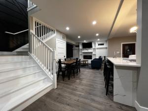 a kitchen and living room with a staircase and a table at Minutes from Anything Downtown Indy! in Indianapolis
