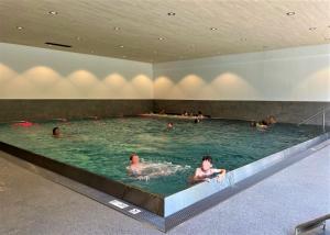 a group of people swimming in a swimming pool at App Steenbok 516 Kleinwalsertal in Mittelberg